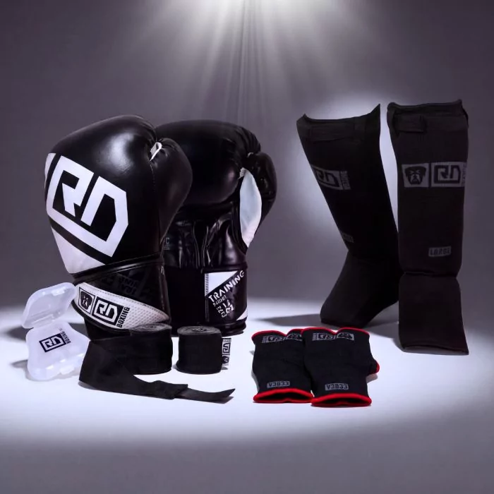 Kit de BOXE THAÏ :
Gants TRAINING V4602
Protege dents
Mitaines ou Bandes en 350cm
Protège tibias V3843 Noir, Rouge et Bleu